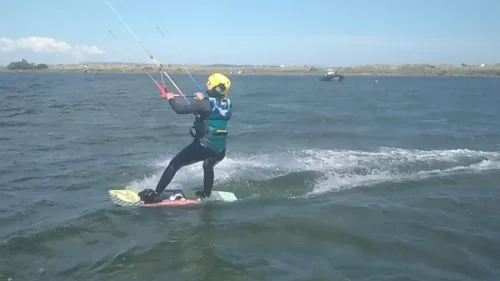 Élève casqué qui navigue en kitesurf pendant un stage